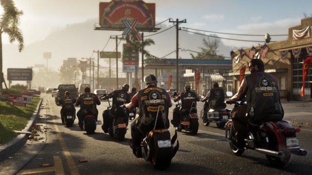 A pack of bikers riding down a sunny small-town road past a sign for the Ambrosia County Sheriff's Office and campaign yard signs.