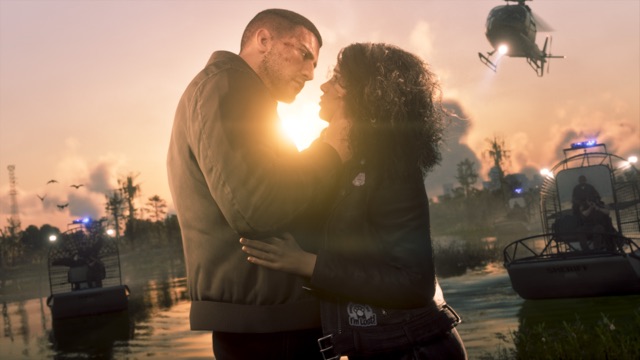 Jason, a cut across his cheek, and Lucia hold each other at sunset in a swamp as sheriff's airboats with flashing blue lights and a helicopter close in around them.