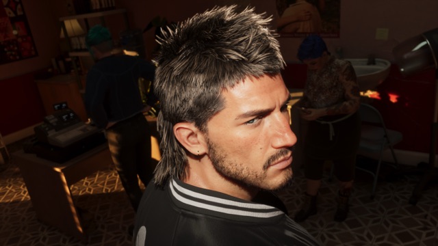 A man in a black bomber jacket, with a spiky feathered mullet and stubble, looks over his shoulder in a dim salon, with a cash register, a hood dryer and two people with dyed hair behind him.