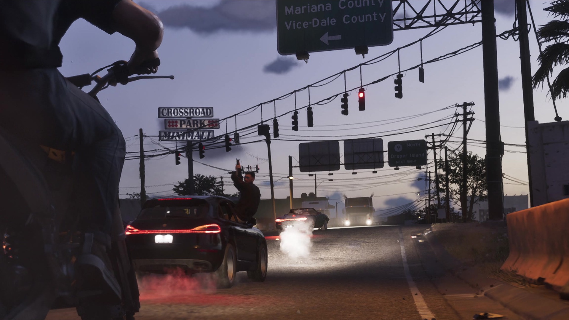 An overhead sign for Mariana County and Vice-Dale County above a street where a motorcycle chases an SUV.