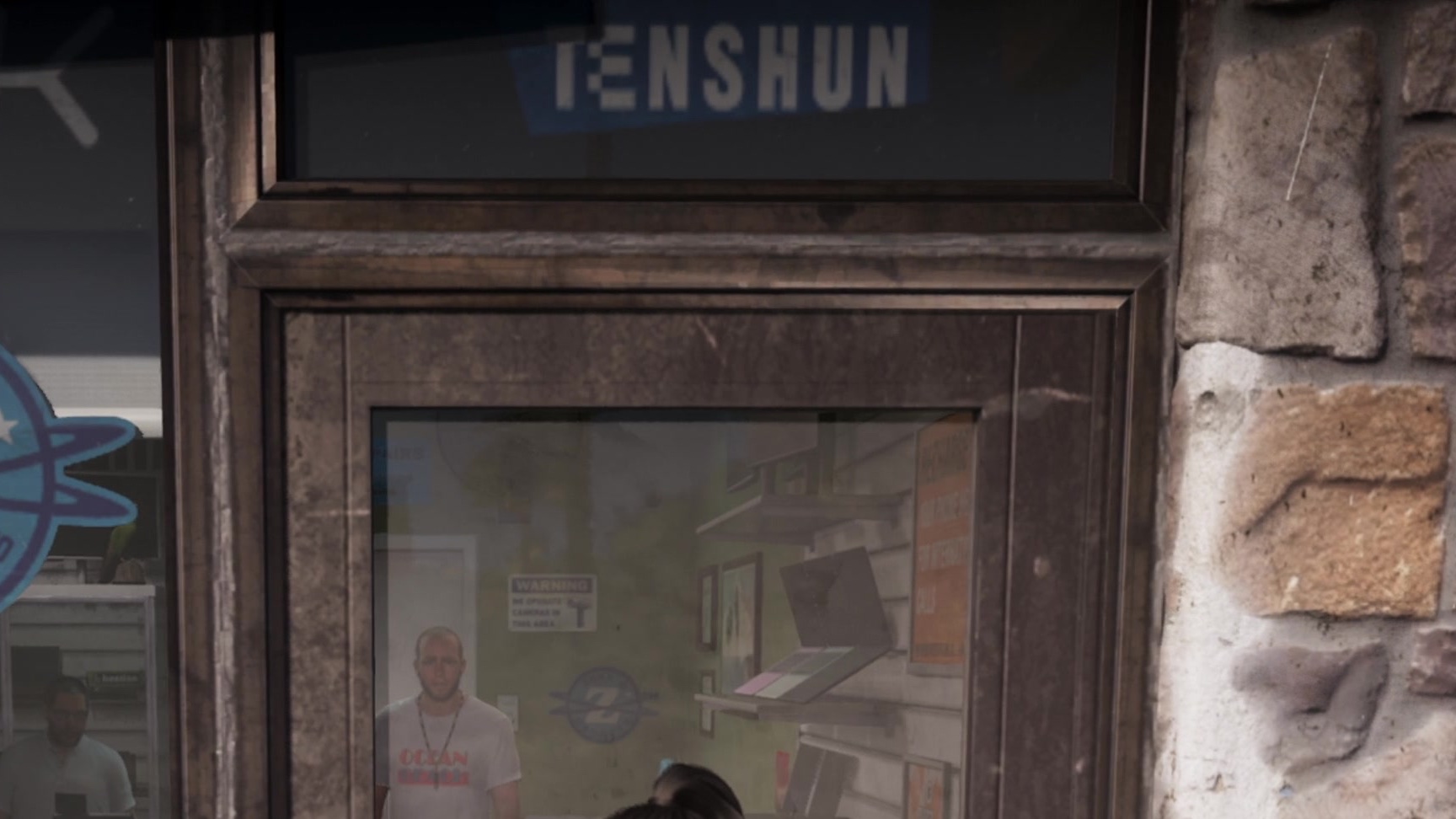 A Tenshun sign in the window of a gadget store, beside a stone wall.