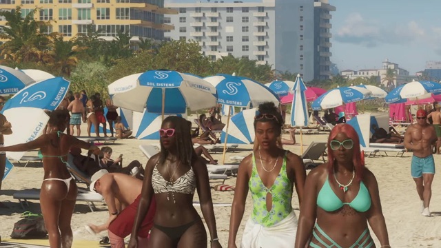 Three women in swimsuits walk across a crowded beach past blue and white Sol Sisters umbrellas printed with Vice Beach.