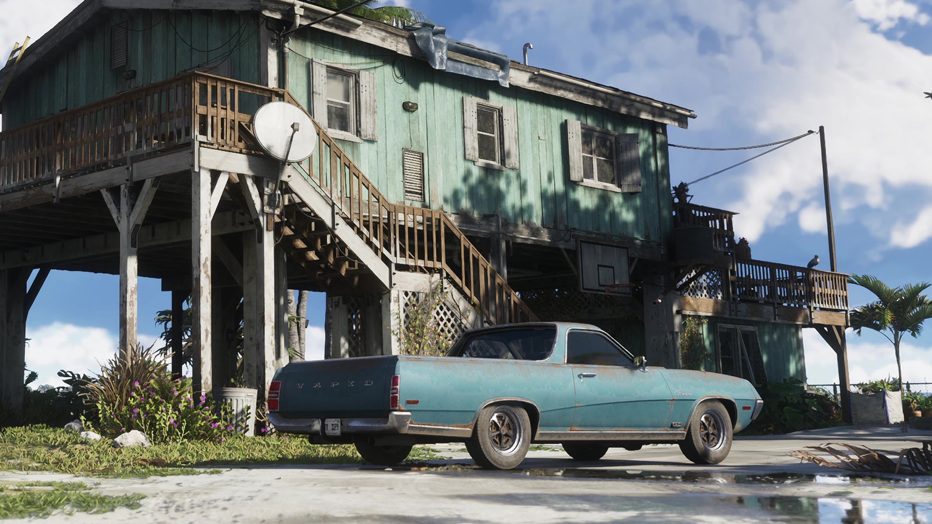 A teal coupe-utility with Vapid across its tailgate, parked under a weathered stilt house.